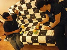 Two people playing Quilt Hopper on a couch